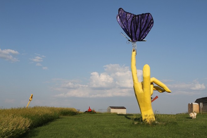 “Nỗi đau và niềm vui” là một bức tượng trong quần thể tượng tại công viên của nhà điêu khắc Wayne Porter ở Montrose, Nam Dakota, Mỹ, với một bàn tay khổng lồ màu vàng bị dằm đâm.
